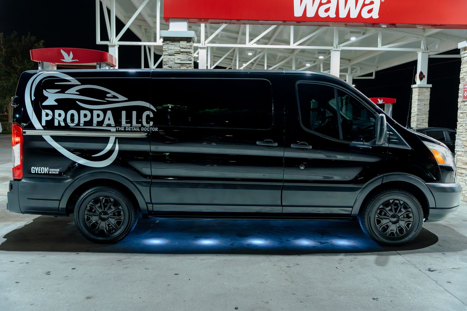 Proppa LLC branded black van photographed at night under station lights
