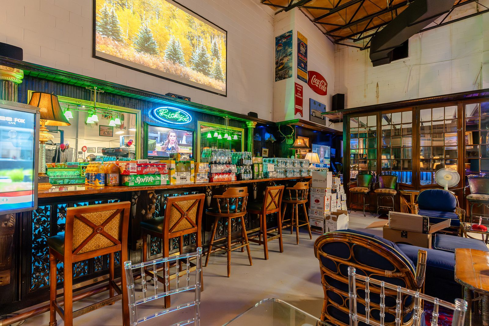 Stocked bar with neon signs and cane barstools