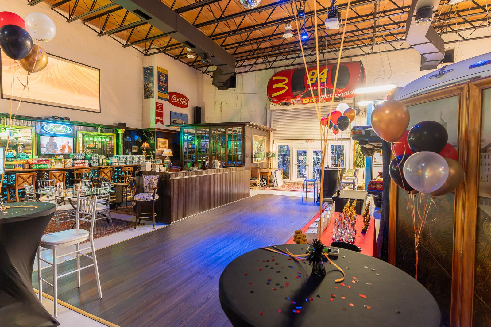Blue-lit floor with cocktail tables and balloons