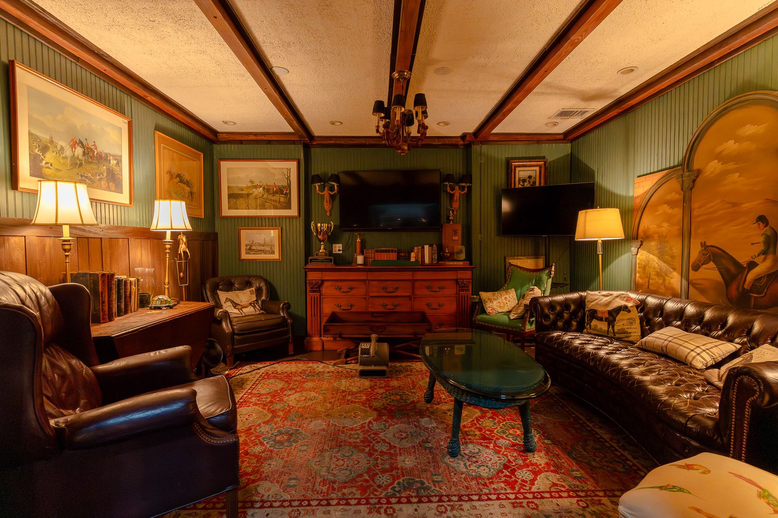 Green lounge with leather chesterfields and a fireplace